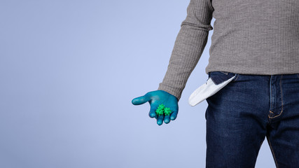 Male half body view. A hand protected by surgical gloves, holds viruses and shows the pocket of his empty pants. Concept of crisis and economic recession caused by coronavirus and covid-19.