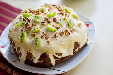Plate with homemade kiwi cake with nuts. Easter cake on the table. Cozy home.