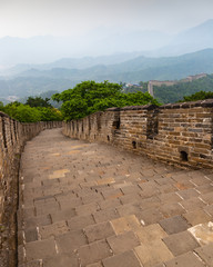 Great Wall of China and surrounding mountains on a misty, summer day