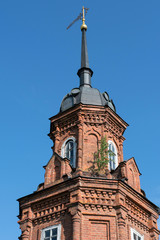 Fototapeta na wymiar Corner tower of Volokolamsky Kremlin with the symbol of the city on the top of the steeple. Volokolamsk, Moscow Oblast, Russia..