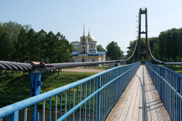 Pedestrian bridge above Volga river and Assumption (Uspenskaya) church. Zubtsov, Tver Oblast, Russia.