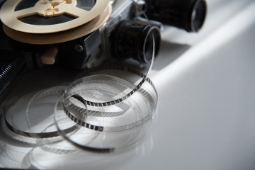 Film roll of film on a reel with a retro movie camera on a light table