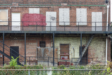 Back of a boarded up abandoned red brick apartment building in urban Atlanta