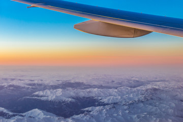 Fototapeta na wymiar Sunrise over Caucasus Mountains seen from passenger plane window