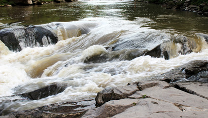 A powerful stream of a mountain river above the stones.