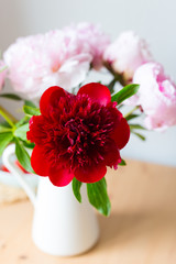 Vase with bouquet of beautiful peonies on table in room, close-up. Bloom. Peony. 