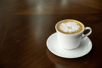A single lonely white cup of cappuccino placed in the empty restaraunt during the pandemic and...