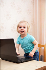 Portrait of   small child with   laptop at home