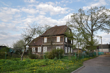 Fototapeta na wymiar Flowering meadow near a wooden house in the city of Volozhin near Minsk in Belarus.