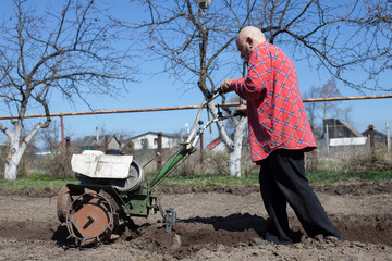 man plowing   land with   cultivator
