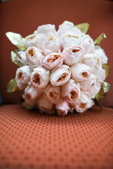 The wedding bouquet lies on a red chair.