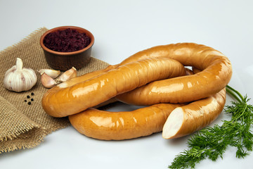 Appetizing sausages with herbs. Meat products. On a white background.