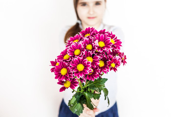 Girl with long hair in a gray blouse with a bouquet of pink red flowers, chrysanthemums, garden, flower and child, beauty, fashion, gift, mother's day, birthday