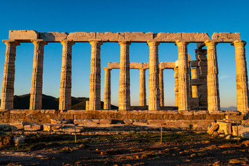 Fototapeta premium Sunshine on ancient columns of Parthenon in Athens against blue sky