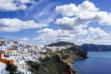Fototapeta na wymiar white houses near tranquil sea against blue sky with clouds in greece