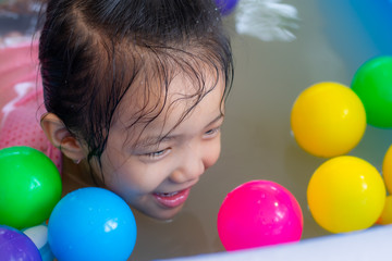 Fototapeta na wymiar Kindergarten girls in Asia play in the inflatable pool.