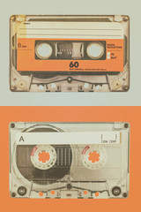 Two old audio compact cassettes on a blue with orange background