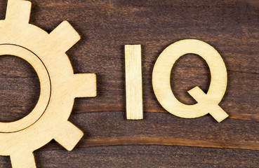 Intelligence quotient, iq test, brain concept, gear with letters on a brown wooden background