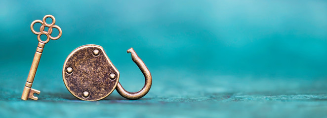 Gold vintage key with unlocked padlock on blue background. Success, business solution concept, web banner.