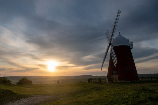 Sunset with sun slipping toward the horizon behind Halnaker windmill near Chichester in West Sussex, the mill is grade 2 listed and dates from the mid 18th century recently restored in 2018.
