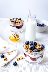 Cooking breakfast with granola and berries on white kitchen background
