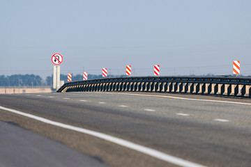 A metal separator of directions on an asphalt road between cities. Road safety