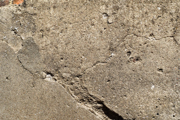dark gray concrete wall with cracks and dents. gray background