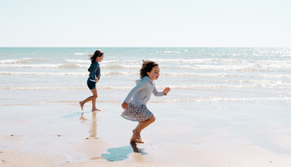 Two young girls enjoying the beach on a beautiful sunny day. French lifestyle