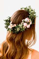 Obraz na płótnie Canvas A bride with beautiful rose and green flower crown on her head. Back shot. Long beautiful hair. Isolated background.