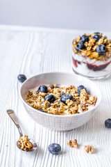 Homemade fitness granola with yoghurt and berries on white kitchen background