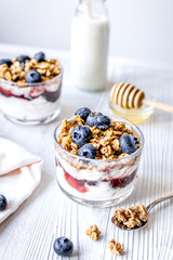 Morning granola with yogurt and berries on white kitchen background