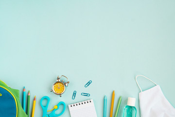 School new reality global pandemic coronavirus covid-19 to school, tools, notebook, medicine mask, sanitizer, school bag  on blue background, stylish banner flyer, flat lay, top view