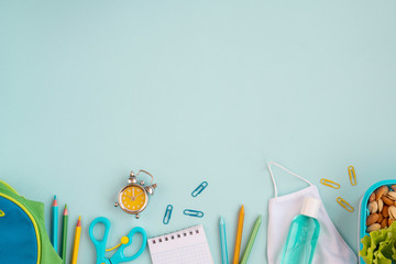 School new reality global pandemic coronavirus covid-19 to school, tools, notebook, medicine mask, sanitizer, school bag  on blue background, stylish banner flyer, flat lay, top view