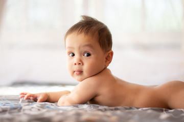 Cute happy  baby boy  in diaper lying and playing