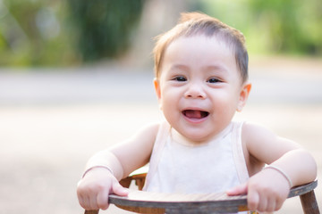 Portrait of baby toddler in baby walker. Expressive child plays toys.