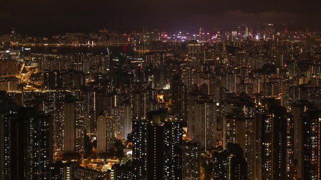 Crowded city with lights turning on and off at night. Hong Kong city apartments buildings at night. Zoom in.