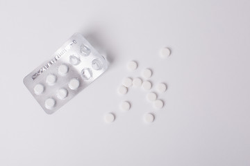 white pills, the empty  blisters of colorful pills on white background
