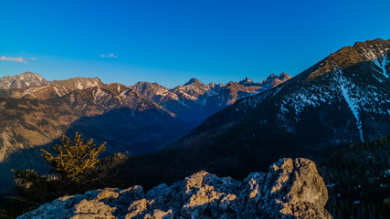 Panorama na Tatry Wysokie z Gęsiej Szyji przy zachodzącym słońcu.