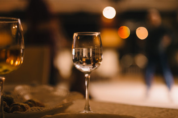 Banquet. Cover the table with a white tablecloth. On the table is glass of wine, dishes with food.