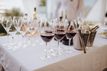 Many glasses with champagne are on the table. The table is covered with a white tablecloth