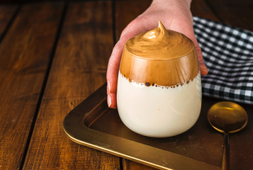 Woman's hand holding a glass of whipped instant coffee Dalgona