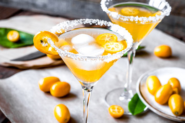 cocktail with kumquat on wooden background