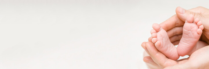 Newborn cute feet in young father hands. Lovely, emotional moment. Close up. Wide banner. Empty...