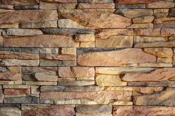 Rocken wall in soft brown colors close up. Stone and brick wall surface. Home and outdoor construction. Architecture