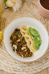 Tasty and healthy breakfast in the cafe. Granola in a pink bowl. Flat lay. Coffee shop concept.