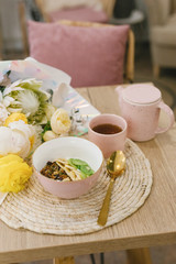 Tasty and healthy breakfast in the cafe. Granola in a pink bowl. Flat lay. Coffee shop concept.