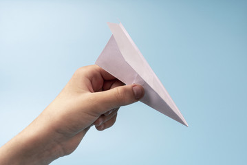 White paper airplane in hand, a symbol of the fall of markets in the airline industry