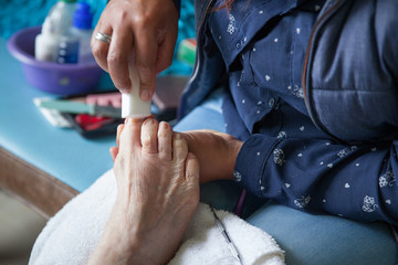 Close up of a senior woman foot while getting a pedicure at home during Covid-19 pandemic