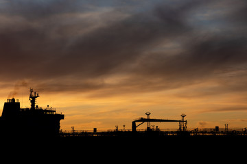 Silhouette of an oil tanker at sunset.