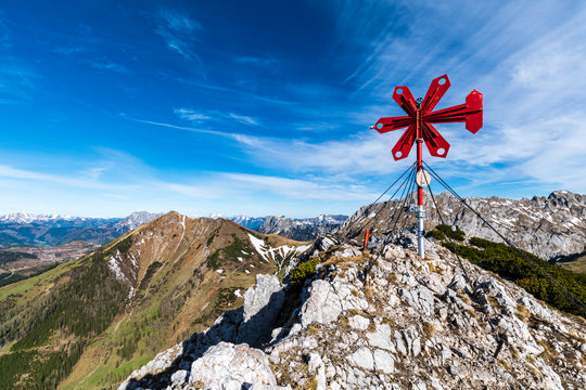 The summit cross of the "Leobner Mauer" mountain with the "Erzberg" and "Polster" mountains in the background on a beautiful day, "Hochschwab" mountain range
